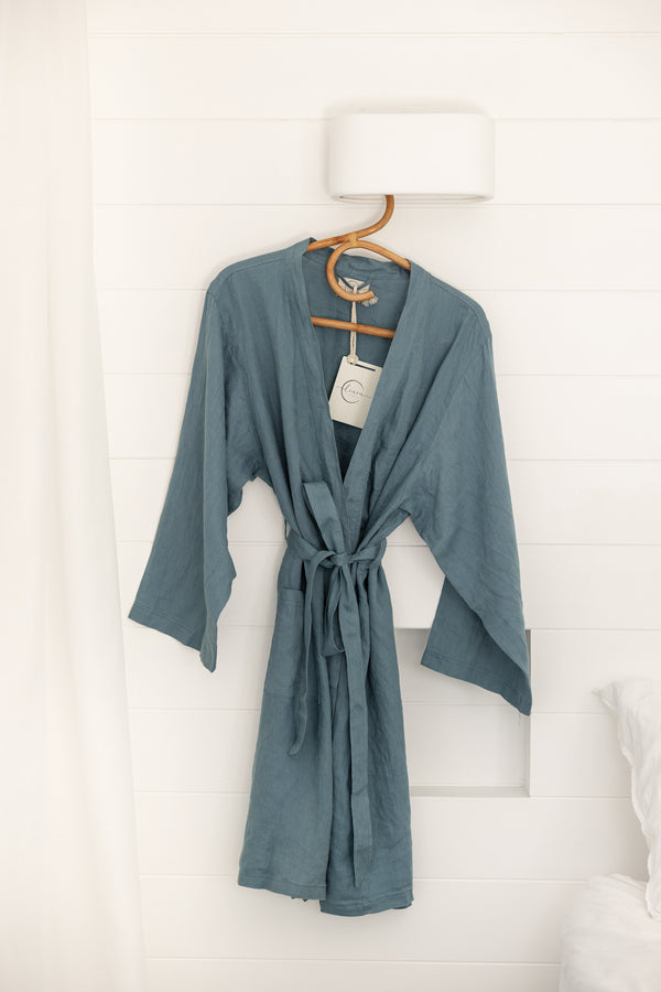 Linen Label Dust Denim Blue French Linen Bathrobe Kimono Robe hanging on a detailed cane hanger - looking luxurious and aesthetically pleasing in a sage green, perfect for ultimate comfort and relaxation. Crafted with 100% French Linen robe showing the mid length 