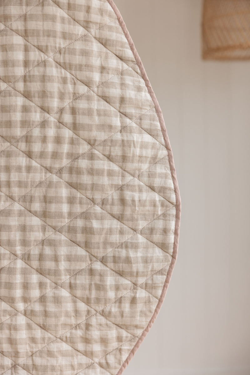 A close photo showing the reverse side of Natural Oat gingham colour side also showing the quilting detail.