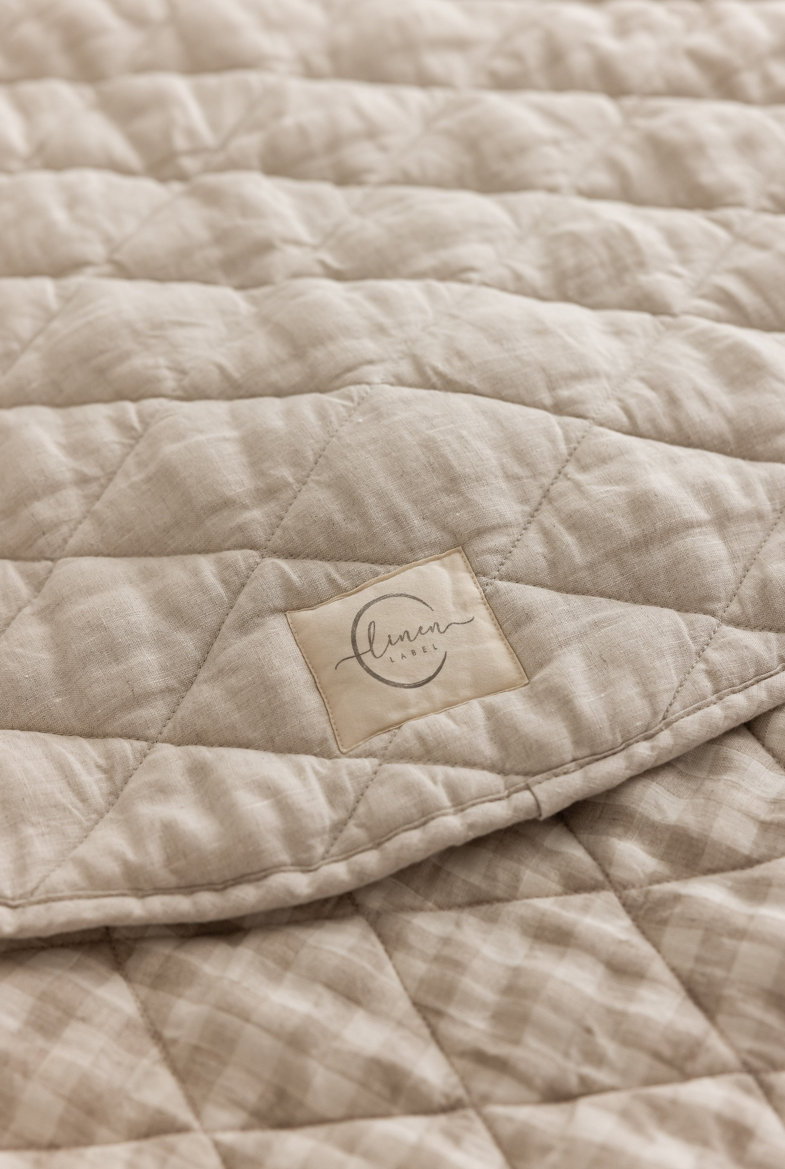 Linen Label Pure French Linen quilted padded play mat folded showing both sides, one Natural Oat colour and the other Gingham check 