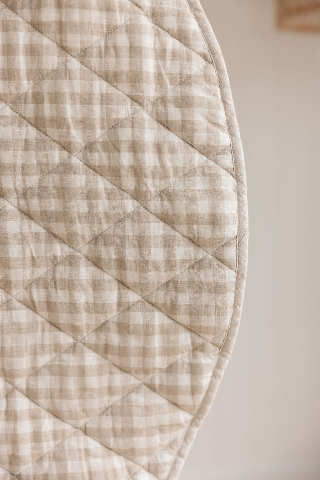 A close photo showing the reverse side of Natural Oat gingham colour side also showing the quilting detail. 