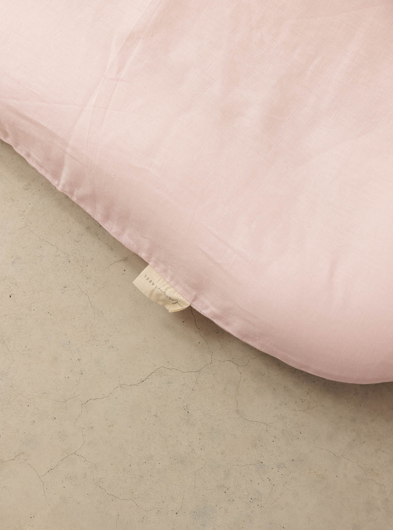 a close up photo of the pure Linen cover on the linen label baby lounger. showing the lining label tag