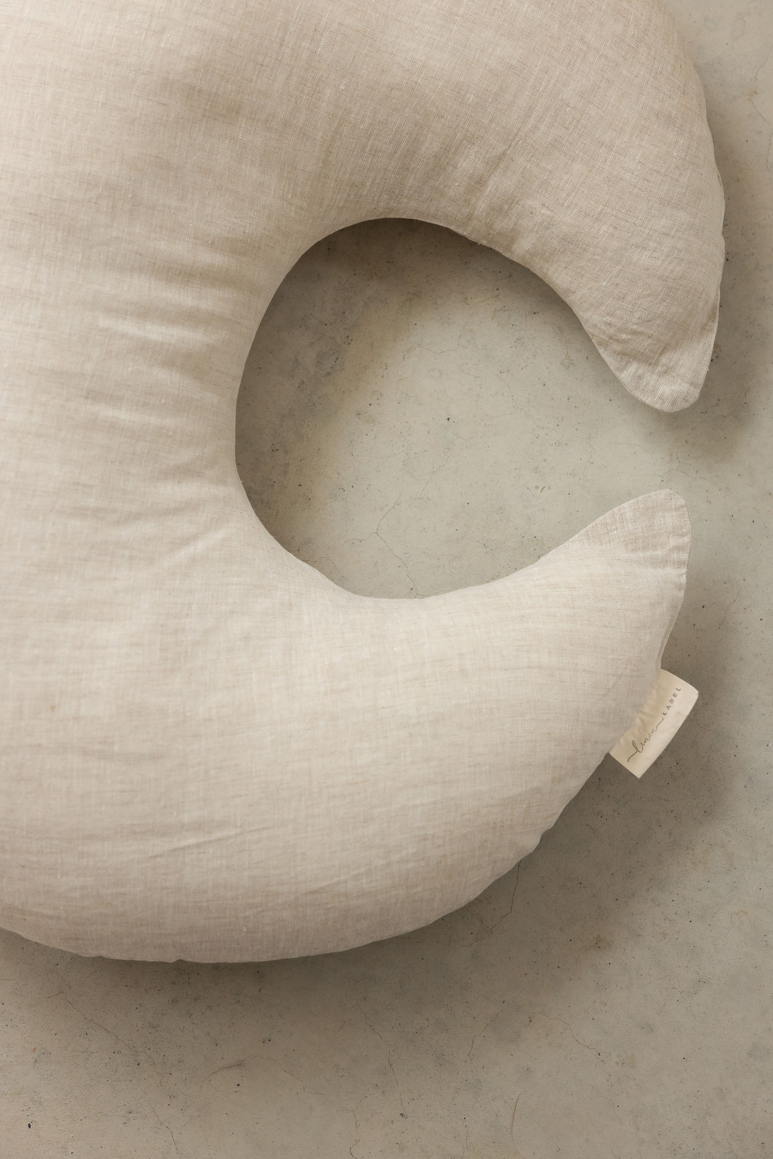 Close up photo showing the detail of Linen Label new pure french Flax Linen nursing pillow in natural design in the new moon shape.