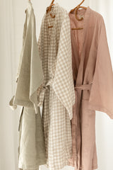 Linen Label Dust Rose Pink, Natural Oat Gingham French Linen Bathrobe Kimono Robe hanging on a detailed cane hanger - looking luxurious and aesthetically pleasing in a sage green, perfect for ultimate comfort and relaxation. Crafted with 100% French Linen that grows softer with each wash