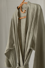 Linen Label Soft Sage Green French Linen Bathrobe Kimono Robe hanging on a detailed cane hanger - looking luxurious and aesthetically pleasing in a sage green, perfect for ultimate comfort and relaxation. Crafted with 100% French Linen that grows softer with each wash