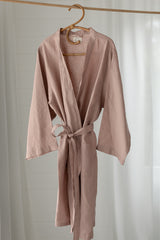 Linen Label Dust Rose Pink French Linen Bathrobe Kimono Robe hanging on a detailed cane hanger - looking luxurious and aesthetically pleasing in a sage green, perfect for ultimate comfort and relaxation. Crafted with 100% French Linen that grows softer with each wash