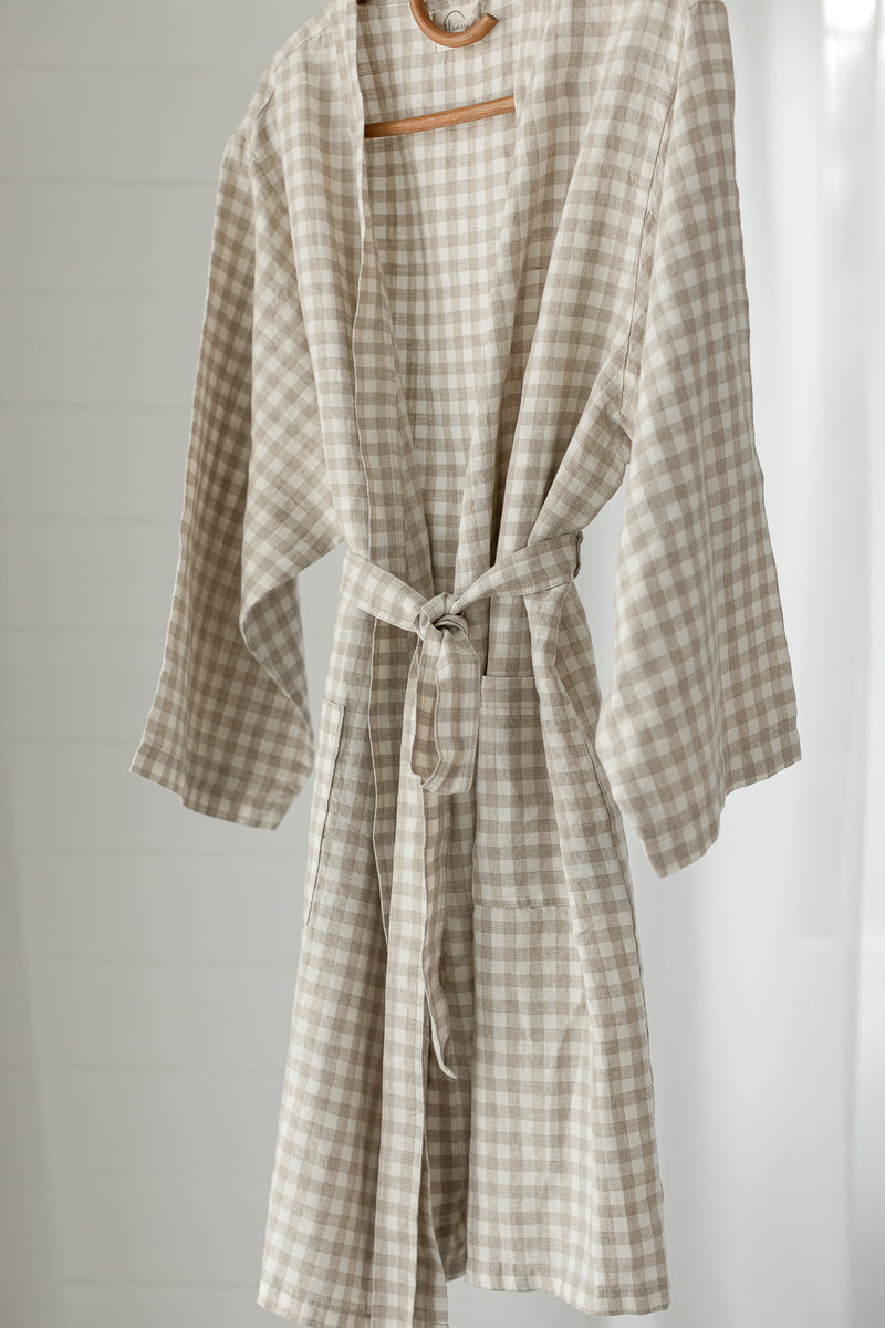 Linen Label Dust Denim Blue French Linen Bathrobe Kimono Robe hanging on a detailed cane hanger - looking luxurious and aesthetically pleasing in a sage green, perfect for ultimate comfort and relaxation. Crafted with 100% French Linen showing the waist time and robe mid length