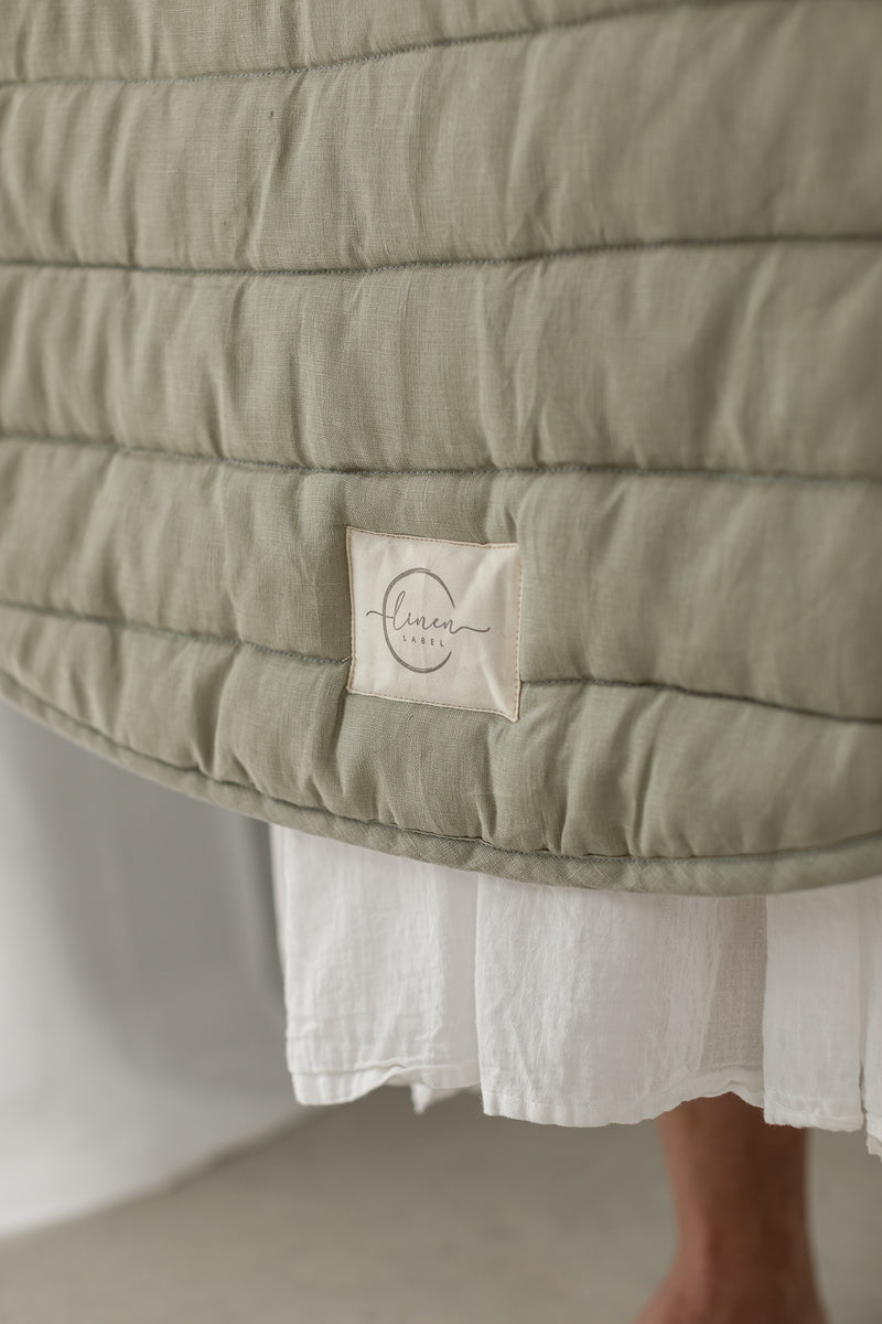 Linen label logo featured on the play mat showing close-up photo of the main side in soft sage as well as showing the quilting detail and high quality of the mat