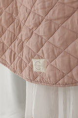 A close photo showing Linen Label logo and the main side Dusty Rose Pink colour side also showing the quilting detail.