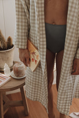 Mother dressed in Linen Natural Oat Gingham French Linen Bathrobe Kimono Robe showing, her robe is worn open showing these robes are perfect for easy breastfeeding days around the home